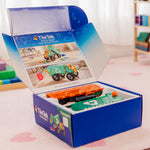 TileTek toy truck set in an open box on a pink carpet with colorful toys in the background
