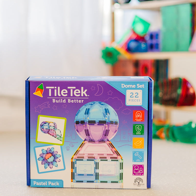 TileTek Dome Set packaging on a surface with a blurred background of colorful toys.