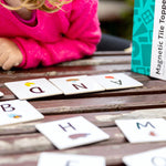Child looking at AND tile topper from pack of learn & grow toys tile toppers