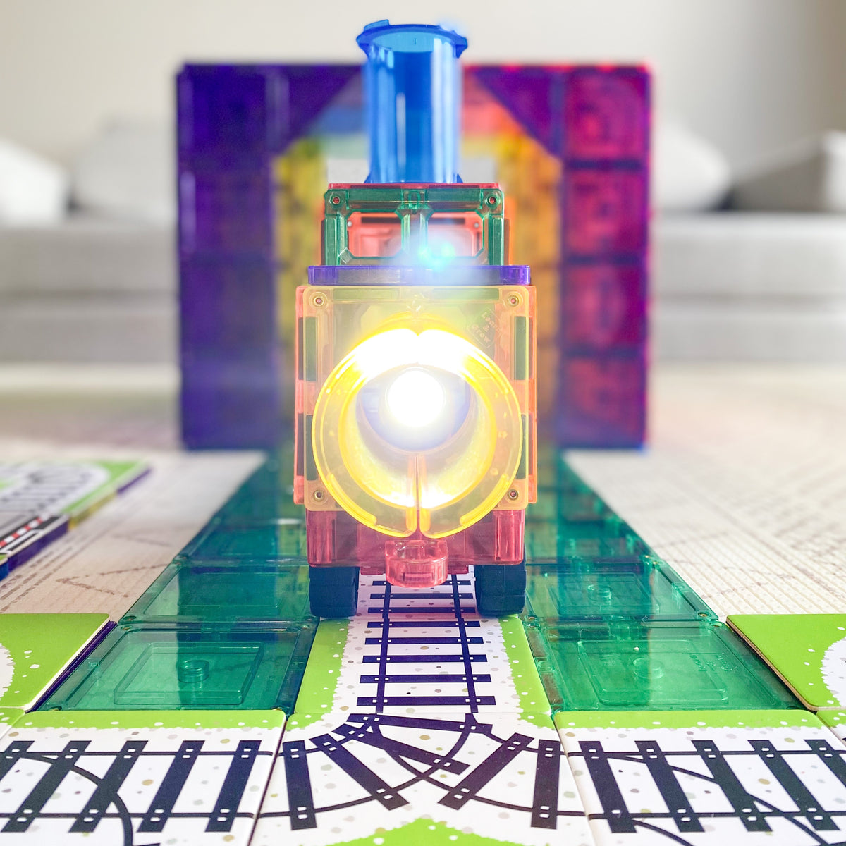 Close up of magnetic tile train sitting on train toppers from Learn & Grow Toys